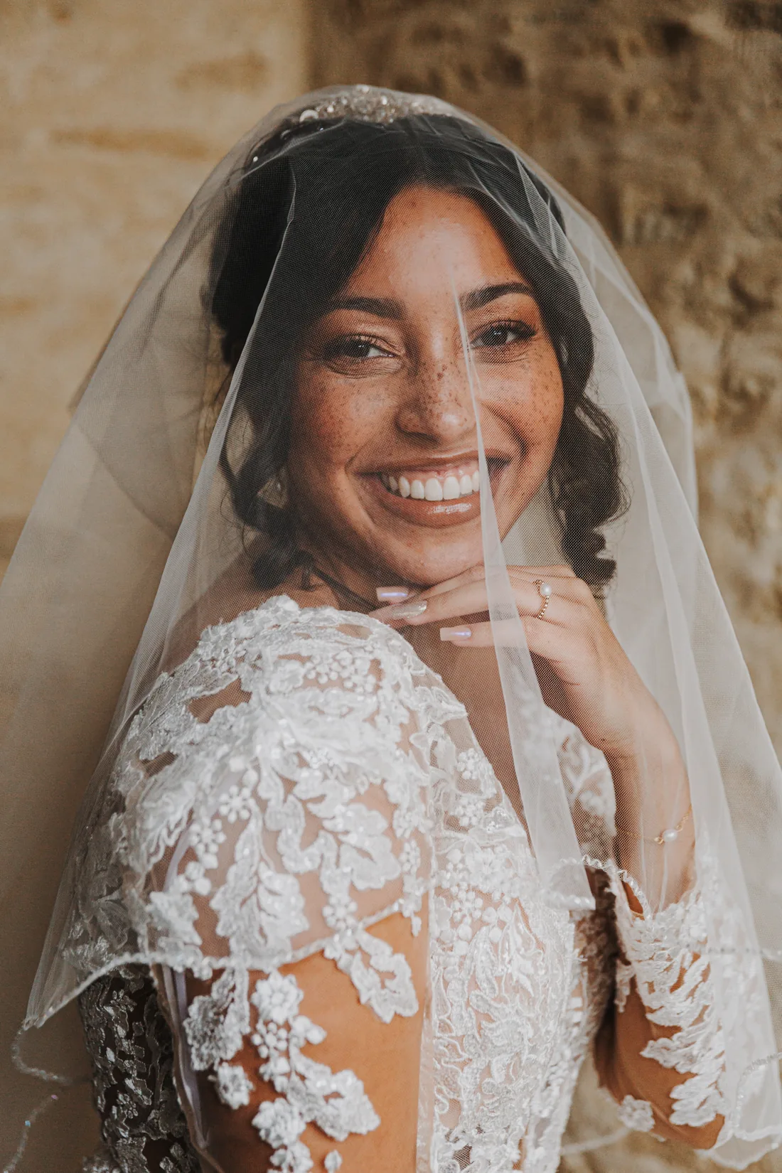 Mariée souriante dans un décor fleuri aux tons doux.